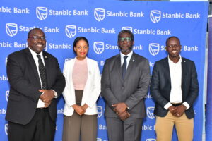 L-R George Muteekanga, the Commissoner for Private Schools at MoES, Sheila Omongo Head Marketing IUEA, Stanbic Bank's Sam Mwogeza, and Isaac Aropet, the Roofings head of corporate affais