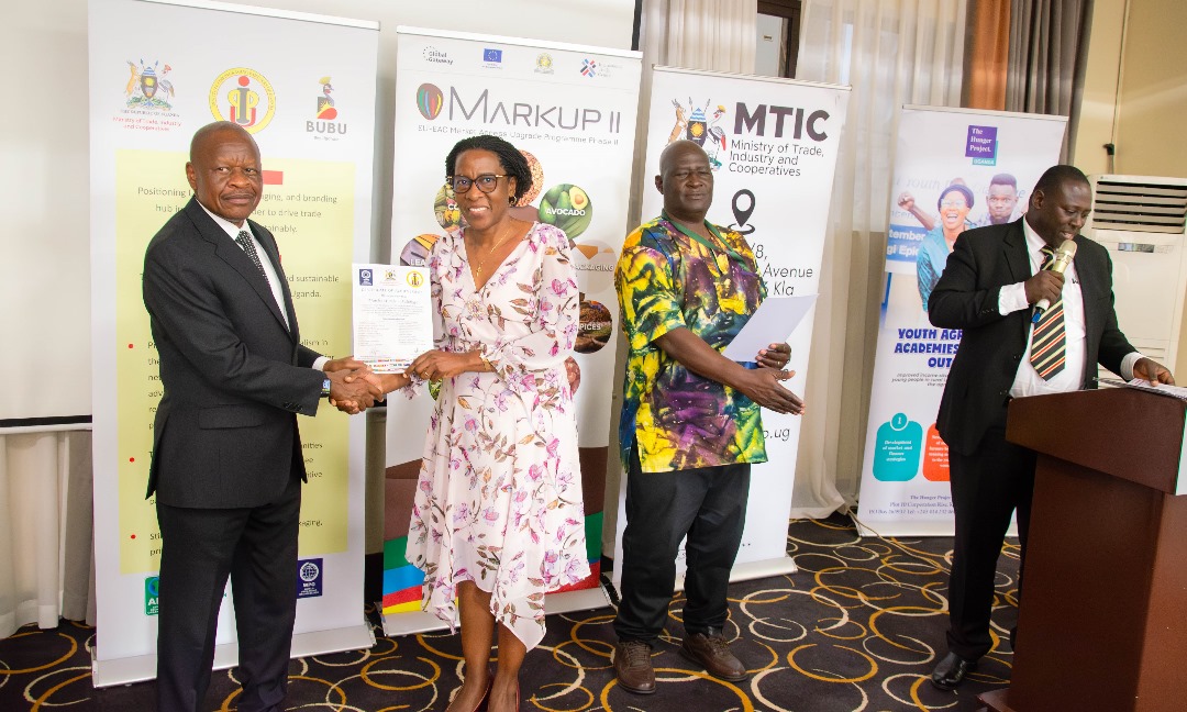 Minister of state for trade. Gen. Wilson Mbadi award a certificate to one of the packaging trainees